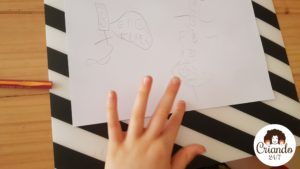mi hijo de 8 años enseñando el boceto a lapiz sobre un folio blanco de sus monstruos. logo de criando 24/7