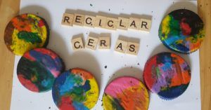 fichas de scrabble de madera formando el texto reciclar ceras y varias ceras multicolor con forma redonda