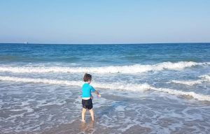 mi hijo mayor de espaldas, en la orilla del mar de Benidorm