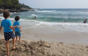 mis hijos corriendo hacia el mar en una cala de Mallorca