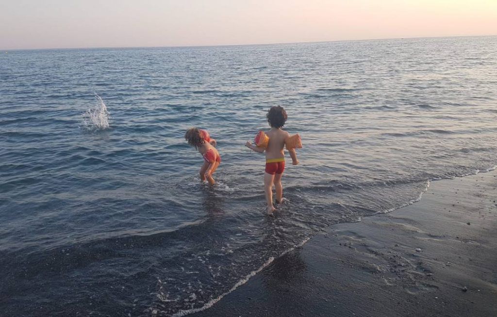 mi hijo pequeño y su primo en la orilla del mar de Torre del Mar, lanzando piedritas al agua