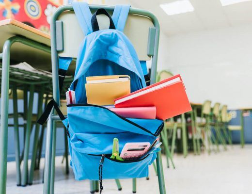 mochila colgada en el respaldo de una silla en una clase de escuela