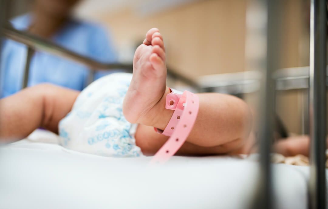 bebé recien nacido en una cuna de hospital