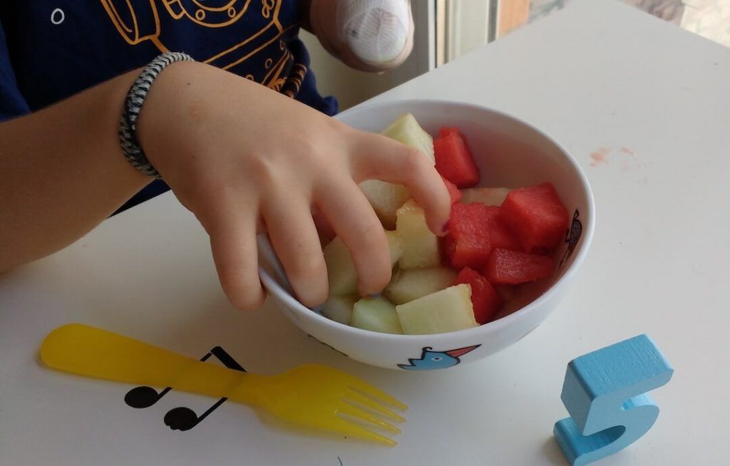 cogiendo fruta en cubos de un bol