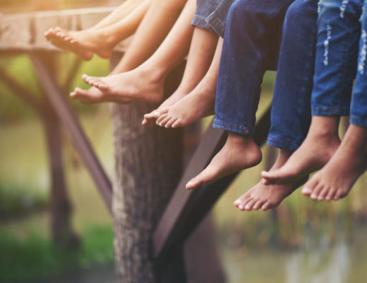 pies descalzos de una familia sentada colgando en un muelle