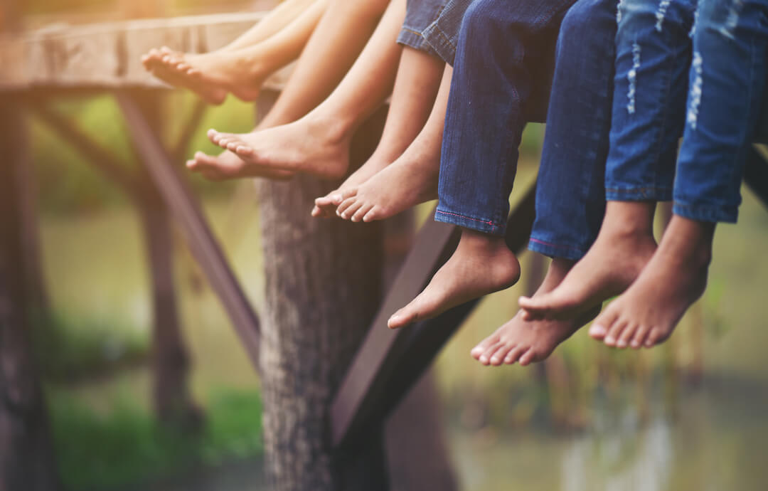 pies descalzos de una familia sentada colgando en un muelle