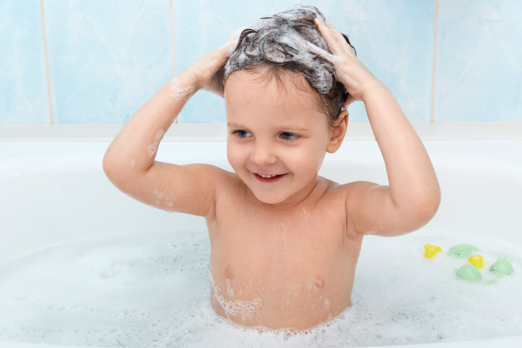 niña pequeña en la bañera lavándose el pelo