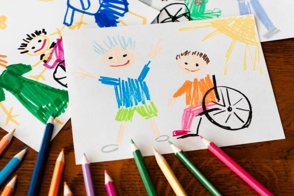 dibujo infantil de dos niños, uno sentado en una silla de ruedas