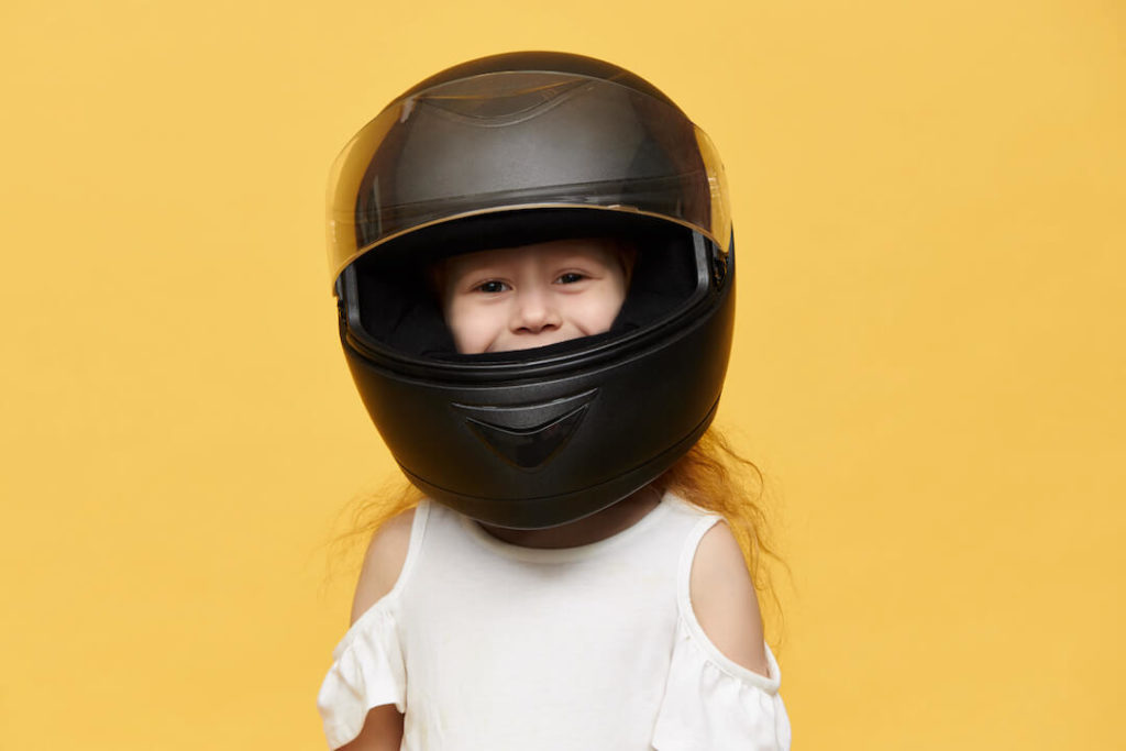 niña con casco de moto sonríe