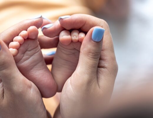 manos de mujer cogiendo los pies de un bebé